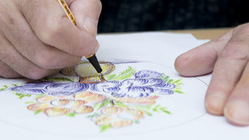Hände beim Zeichnen einer Blumenvase.