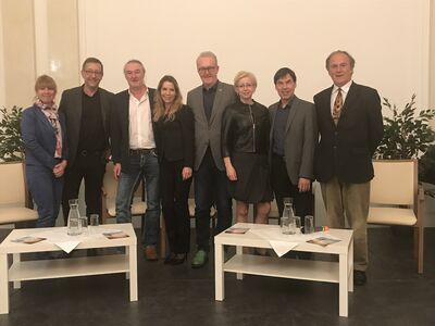 Acht Personen auf einem Gruppenfoto.
