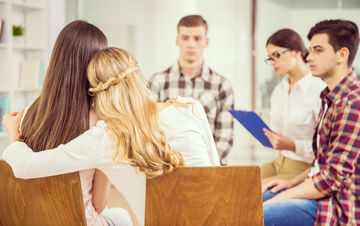 Gruppentherapie mit fünf jungen Menschen.