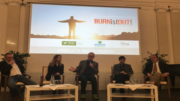 Bühne mit fünf Speakern und Leinwand im Hintegrund.
