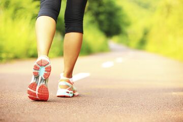 Weibliche Füße beim Joggen im Grünen.